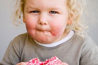 Kind mit Übergewicht isst einen Donut